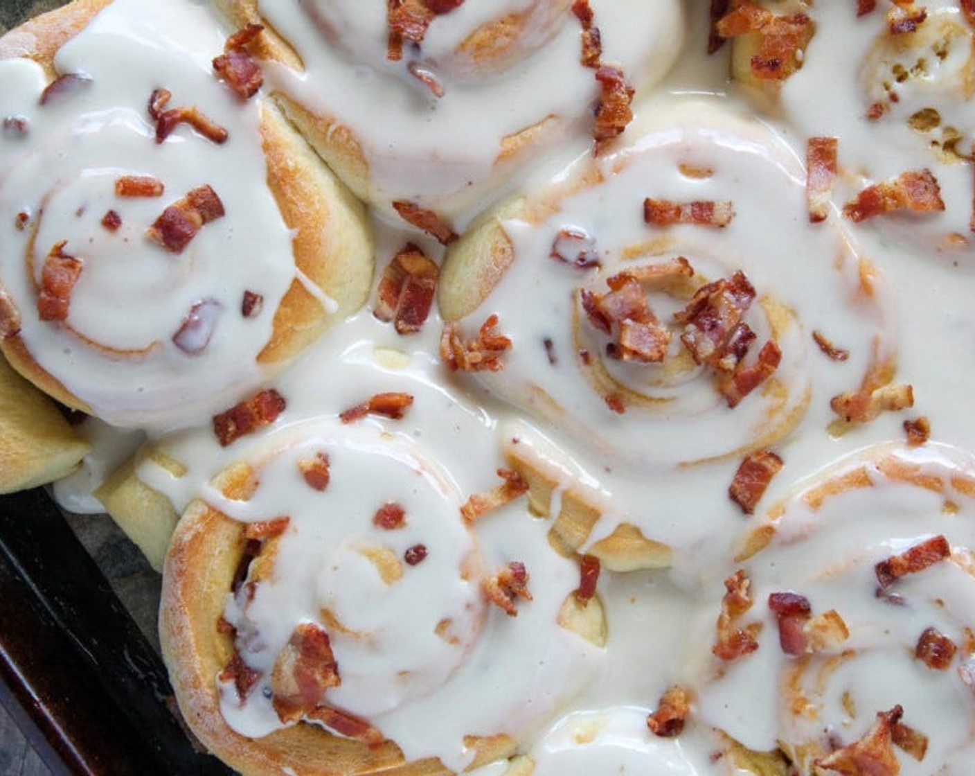 step 14 Remove from the oven and let cool for 15 minutes. Once rolls have cooled slightly, spread frosting evenly over all of the rolls and sprinkle with the remaining cooked bacon pieces.