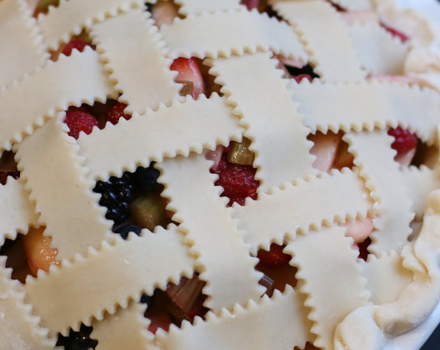 step 15 Carefully weave the strips into a lattice over top of the pie. Using a small knife, trim the extra overhang. Crimp the edges of the dough with your fingers.