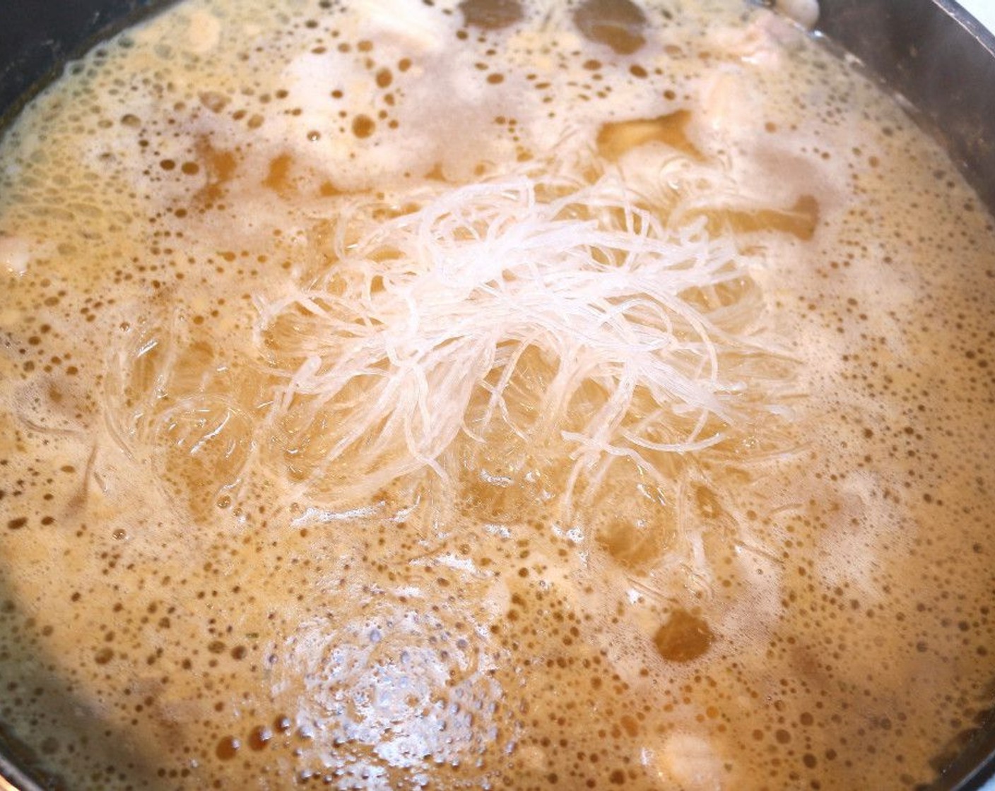 step 7 When the pork cubes are tender, add the rice sticks. Skim off the impurities one more time.