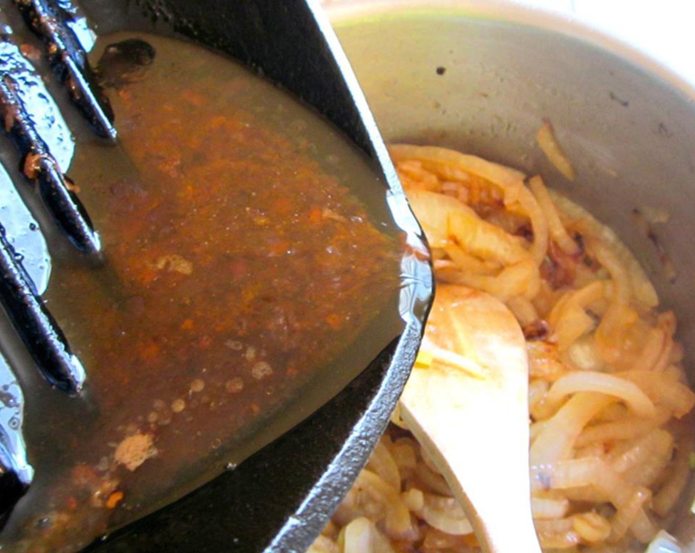 step 9 Add the juices which have collected from the resting lamb leg to the yellow onions.