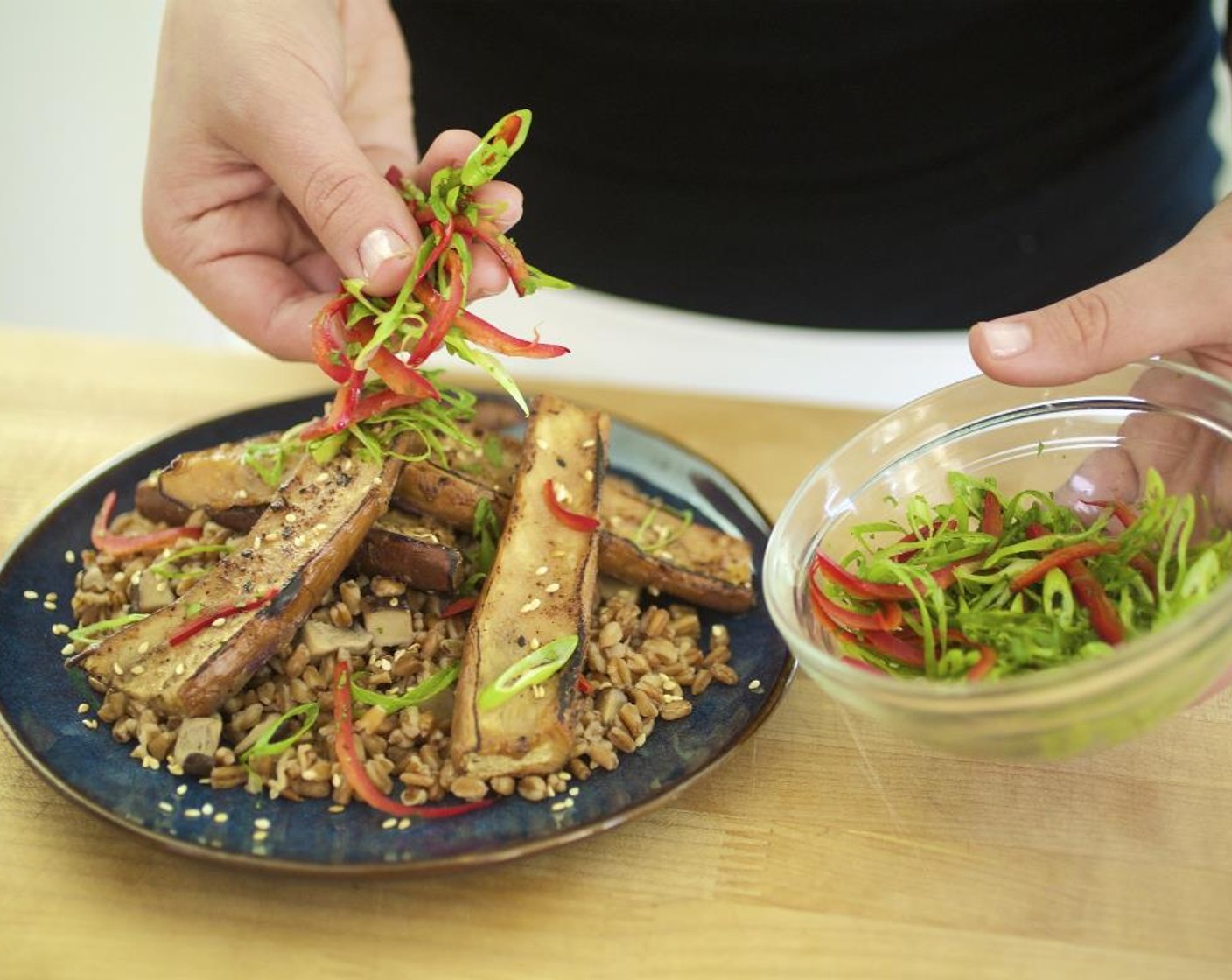 step 16 Place a scoop of farro in the center of two plates. Top with the roasted eggplant and place the salad on top.