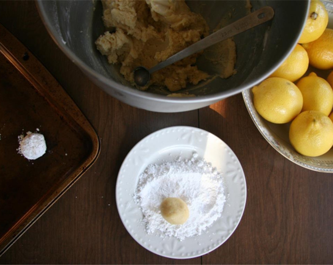 step 4 Refrigerate the dough for 20 minutes. Preheat the oven to 350 degrees F (180 degrees C). Place the Powdered Confectioners Sugar (1/2 cup) onto a plate. After 20 minutes, scoop the dough out using a teaspoon and roll into balls.