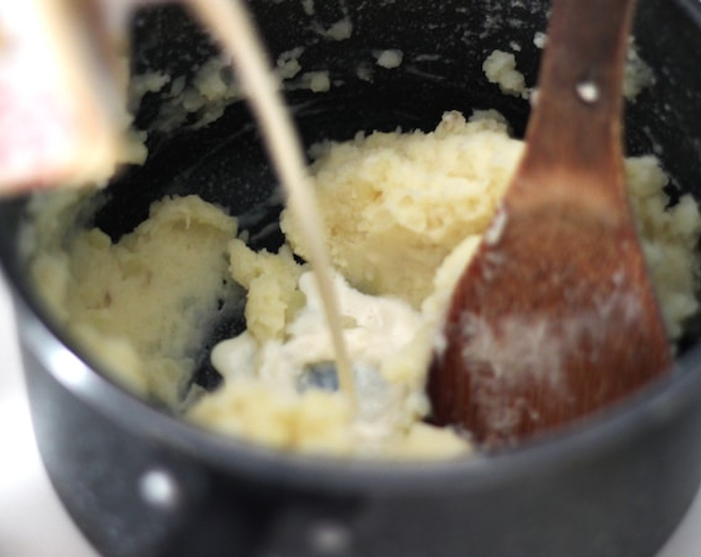 step 12 Add Soy Milk and Vegetable Stock (3 Tbsp) to your mashed potatoes. By adding more moisture it gets easier to spread it on top of the pie.