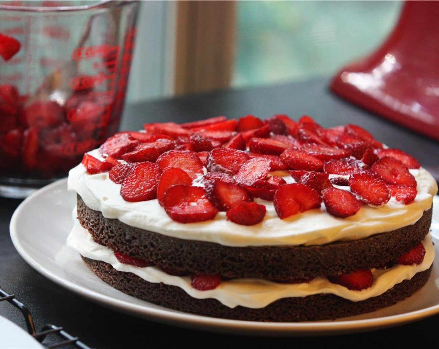 step 15 Place one of the small layers onto a plate or serving platter. Spread 1/4 of the whipped cream over the top of the cake layer to the edges, leaving the sides bare.