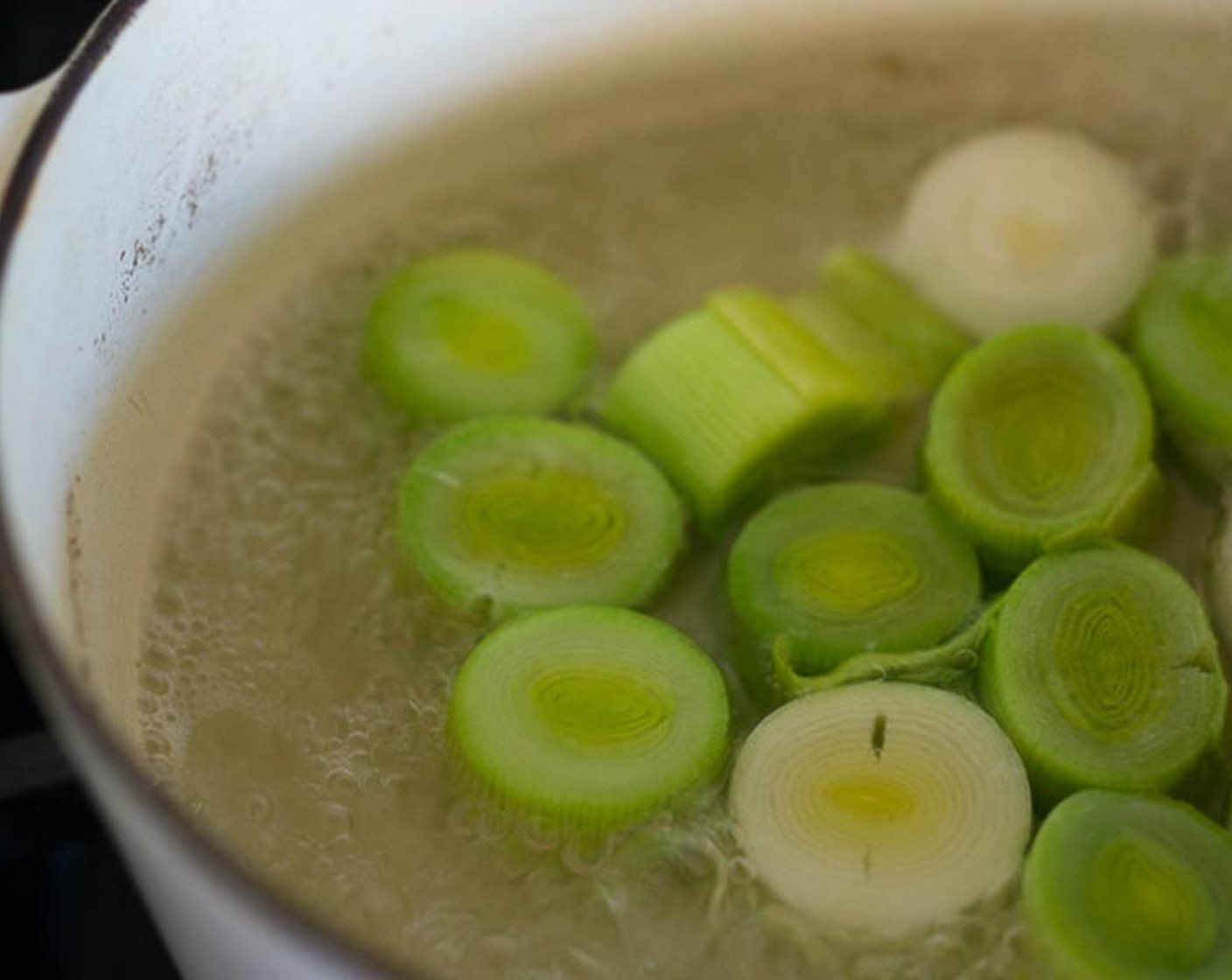 step 4 Set leeks in a saute pan with 1/2 inch of water (coming up half way up the sides of the leeks) bring to a boil, turn heat down and simmer on low for 5 minutes, until tender, and vibrant green. Drain, carefully, so they stay intact.