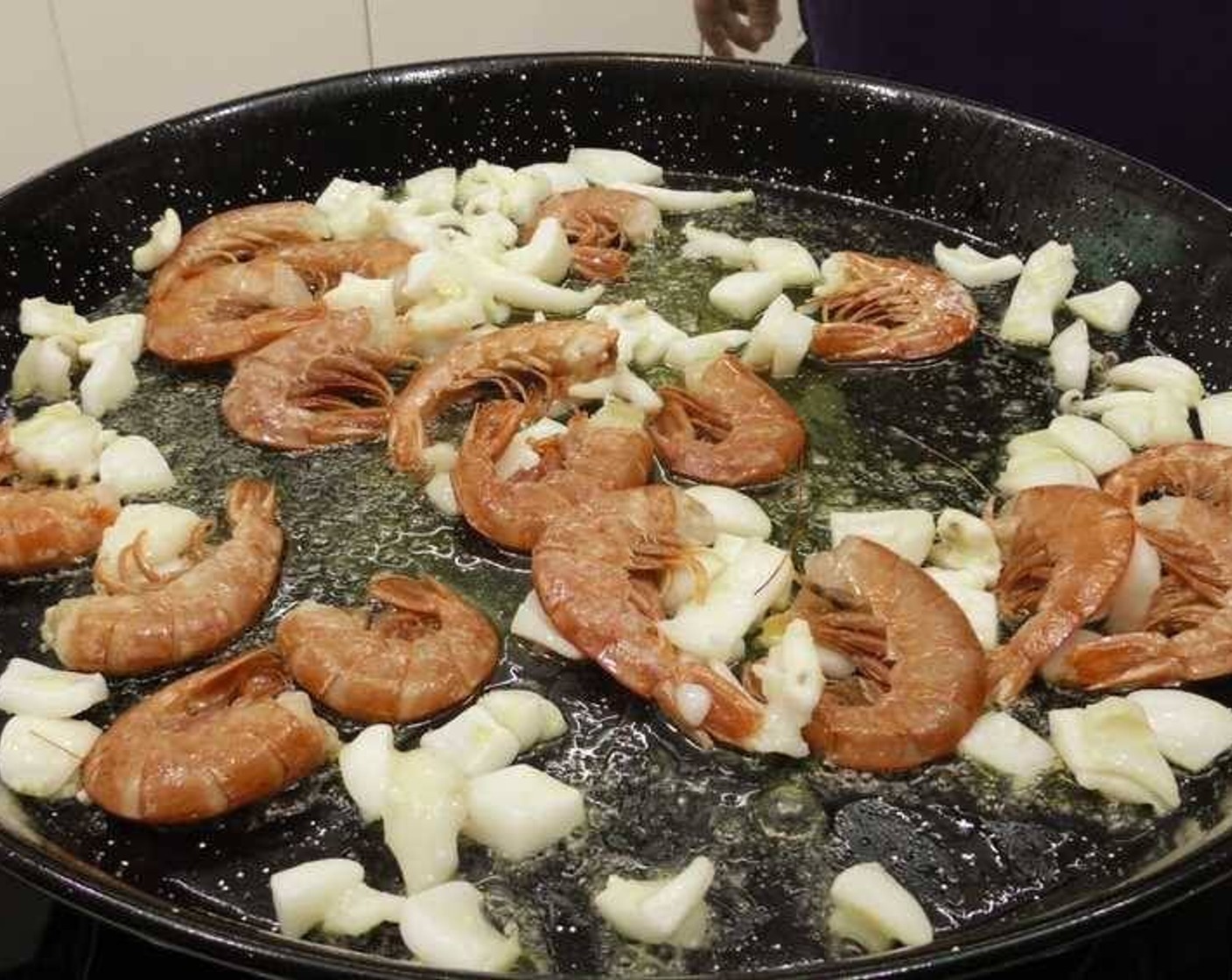 step 1 Clean up and cut the Calamari (4) into small pieces. Add enough Olive Oil (as needed) to cover the bottom of a large pan, and once hot add the calamari and the Langostinos (16).