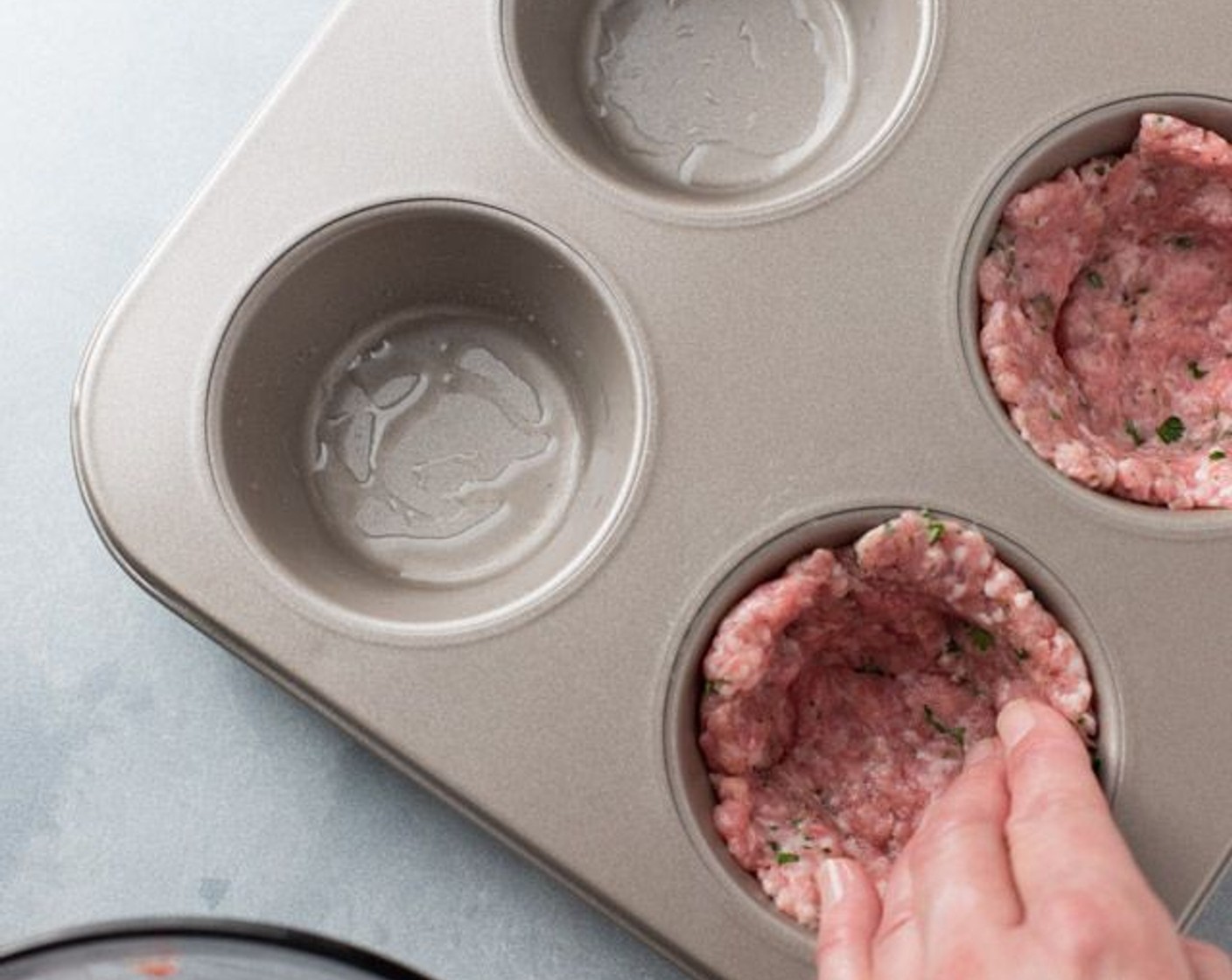step 4 Divide the sausage mix into 6 balls. Flatten each into a large patty and place individually into the muffin tins, forming a shell leaving room for eggs.
