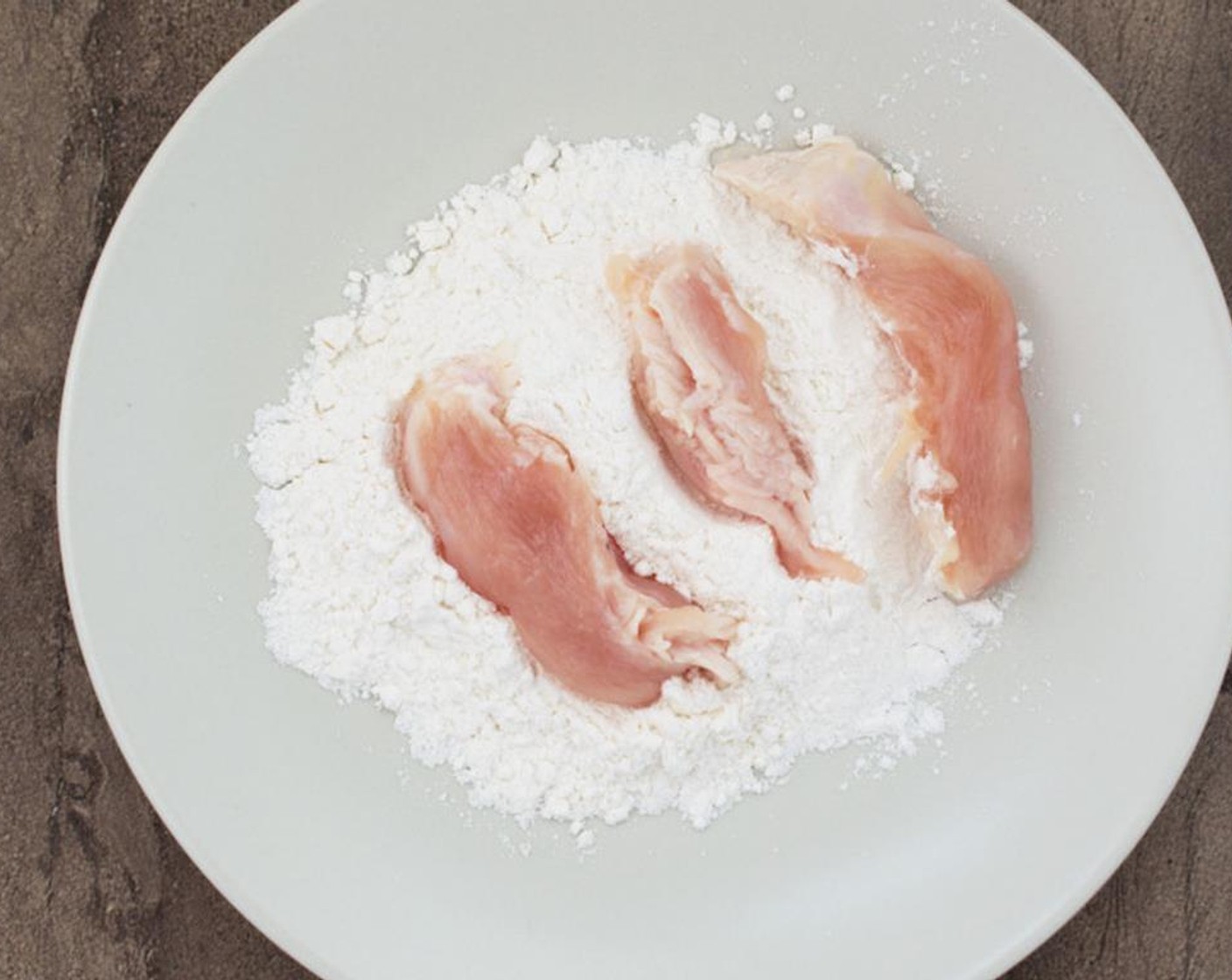 step 4 Coat chicken tenders in flour. Pound chicken with the palm of you hand while you are doing this. It will help the chicken cook evenly.