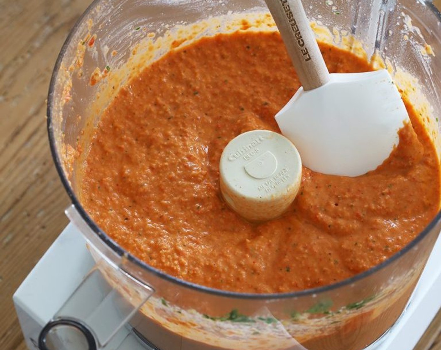 step 5 Using a rubber spatula, scrape the tomato paste and oil mixture into the food processor. Process or blend on high, adding more liquid from the jar of peppers (or water) if the hummus is too thick, until smooth and creamy.