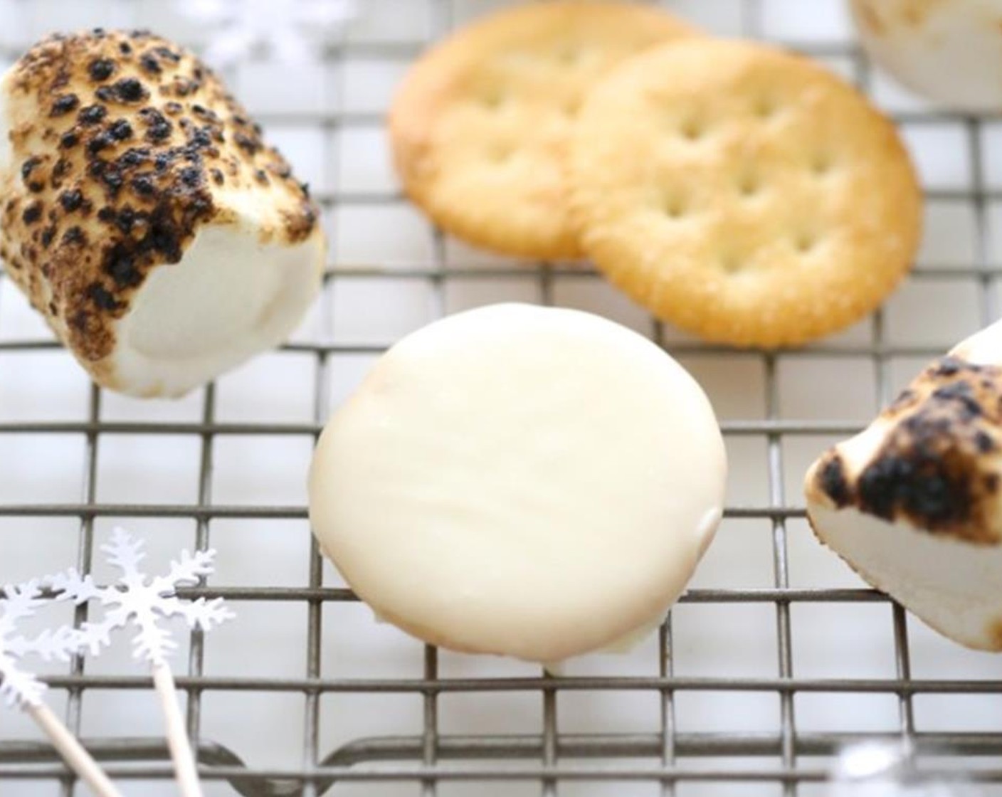 step 2 Remove saucepan from heat and begin to dip the Round Crackers (12) into the melted chocolate and place the cracker on a sheet of parchment paper. Repeat the process until all 12 crackers have been covered in white chocolate.