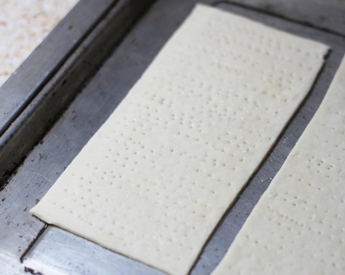 step 10 Remove the hot baking sheet from the oven and carefully place each piece of dough on to it. Place back in the oven and bake until the surface of the Matzoh is bubbly and golden, around 30 to 90 seconds.