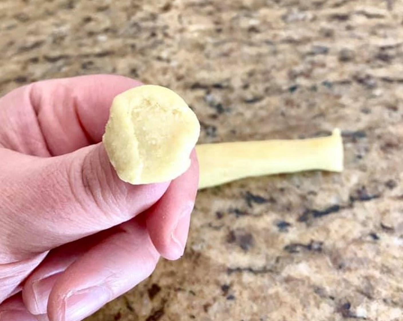 step 6 In one motion, press on the dough very firmly with the knife and drag it across so that the dough rolls around it. Unroll it around your thumb to form the signature little ear shape.