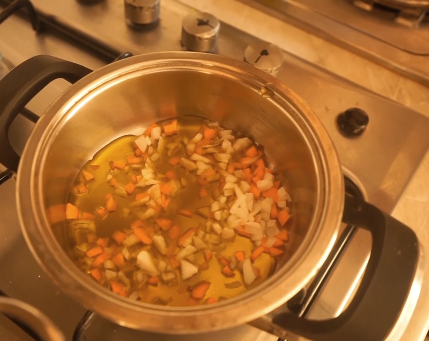 step 5 As the beans cook, put a pot on the stove and drizzle Extra-Virgin Olive Oil (as needed) along with Carrot (1/2) and Onion (1/3) letting them sauté.