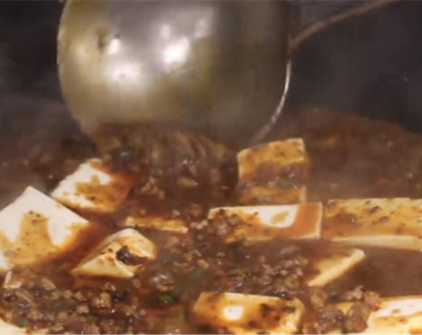 step 15 Add silken tofu and turn the heat to medium. Pour the sauce over the tofu, don't stir. Use a ladle in a forward motion to push the tofu around. Cook for two to three minutes.