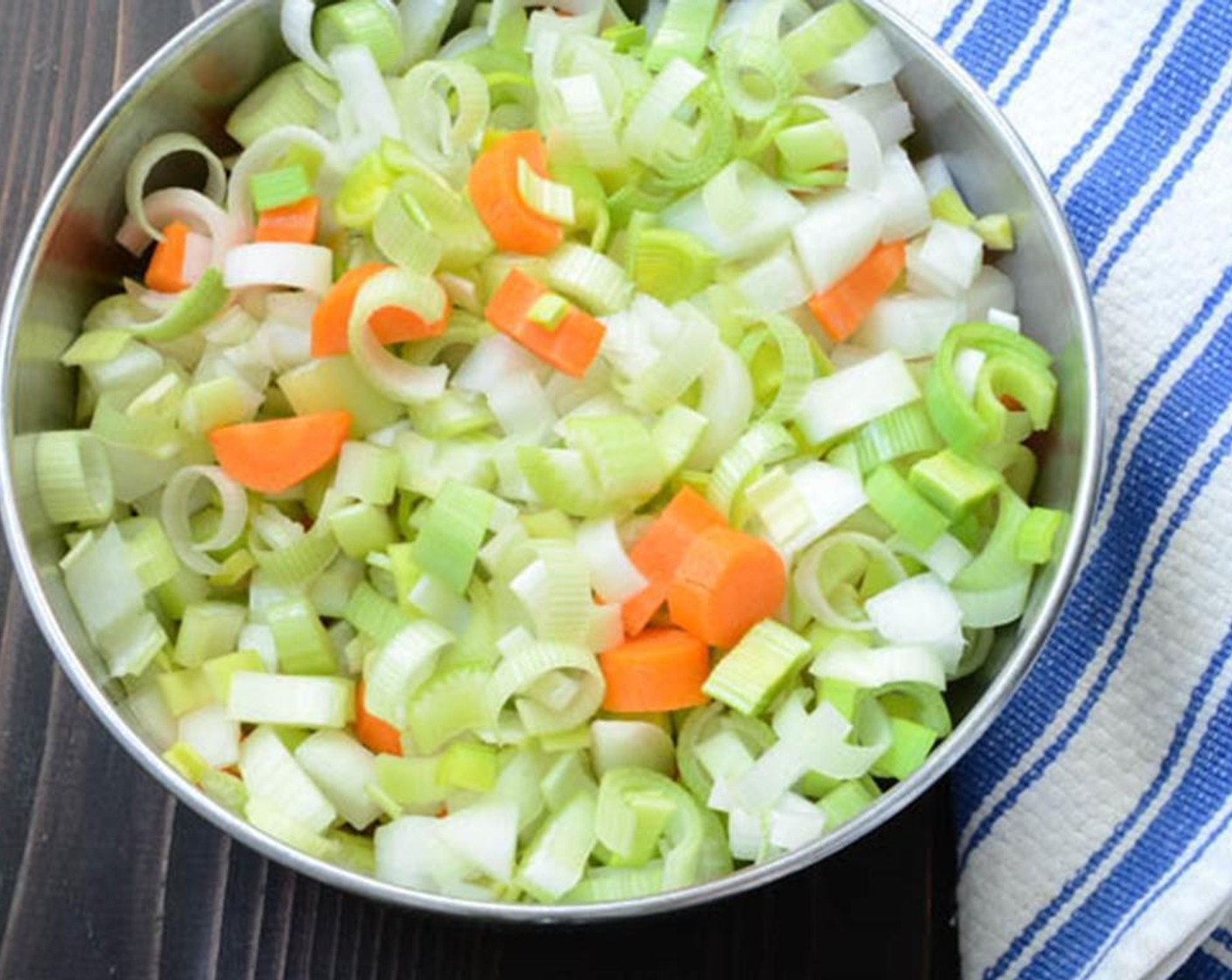 step 5 Chop the Celery (2 stalks) and Carrots (3) into half-inch dice. Clean Leek (1) of any grit, slice in half lengthwise and cut into half-inch Onion (1) into half moon slices.