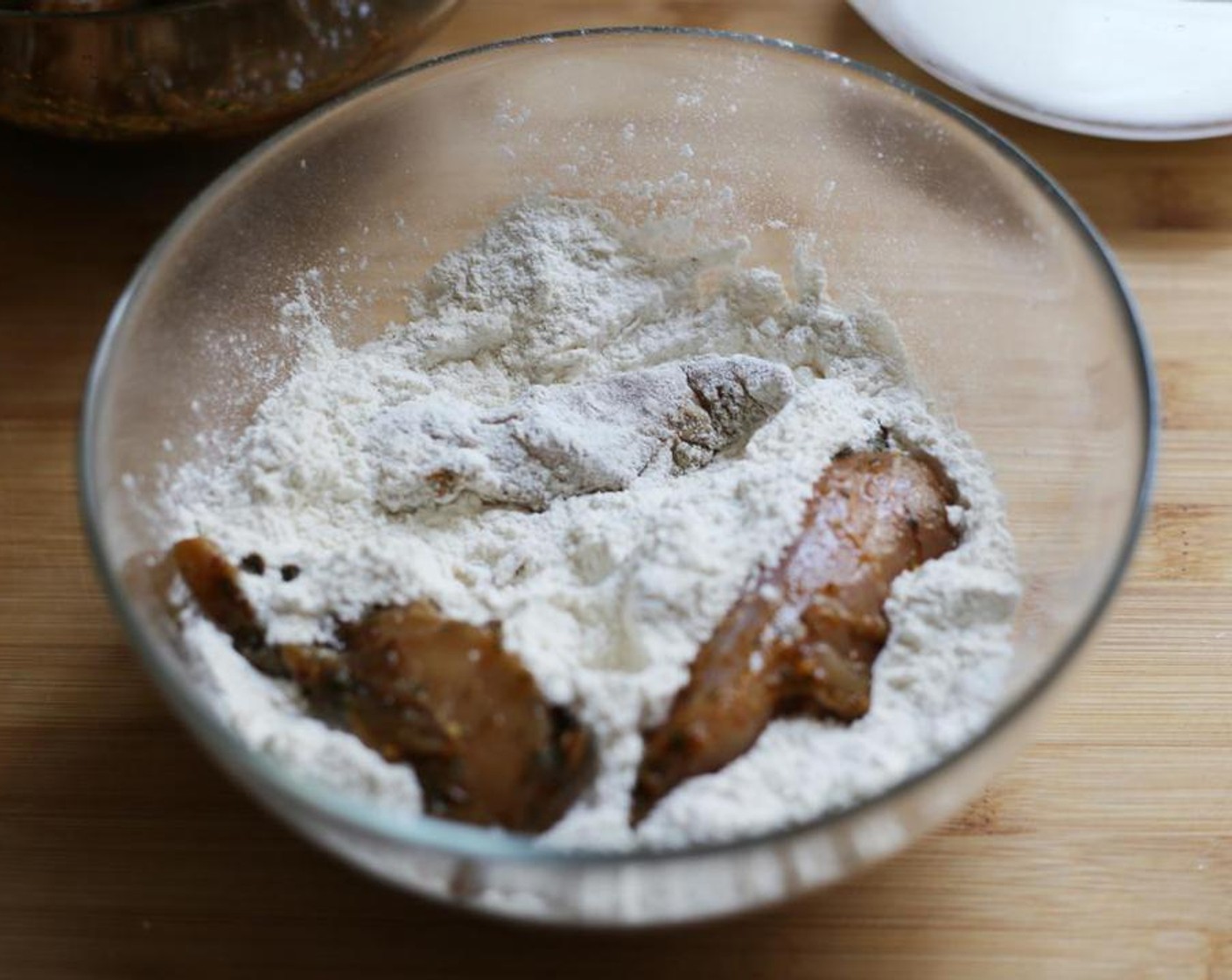 step 6 Working in batches of three, remove the tenderloins from the bowl and let excess marinade drip off. Dredge in the flour mixture, shaking off any excess.