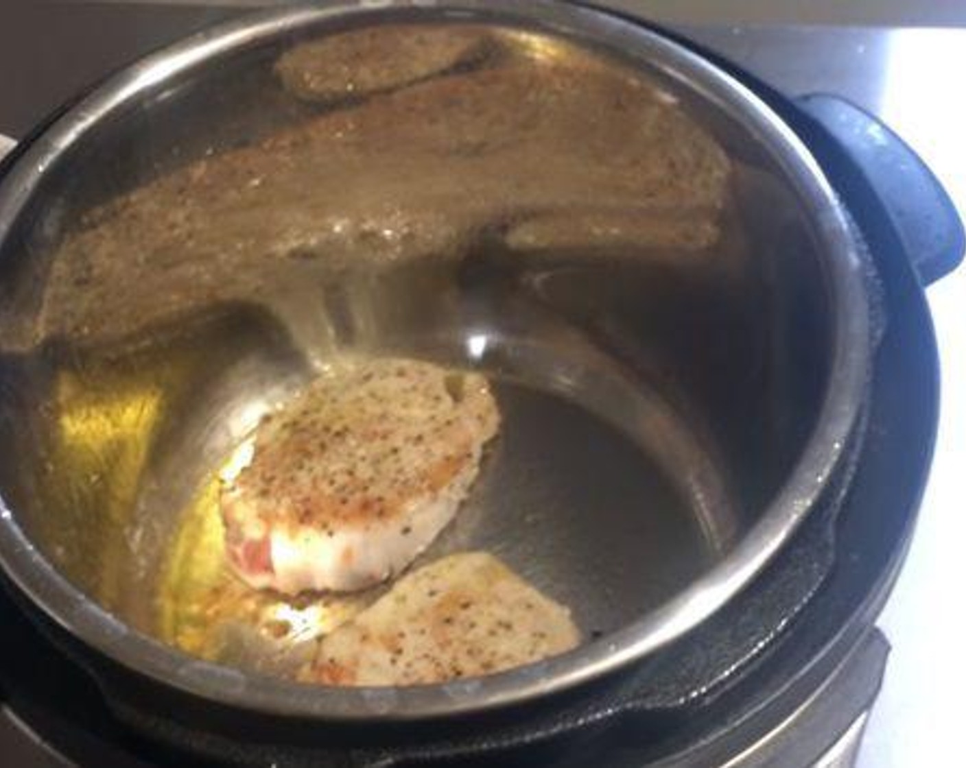 step 3 Heat up some Olive Oil (1 Tbsp) in your pressure cooker. Then cook your pork chops for about a minute on each side.