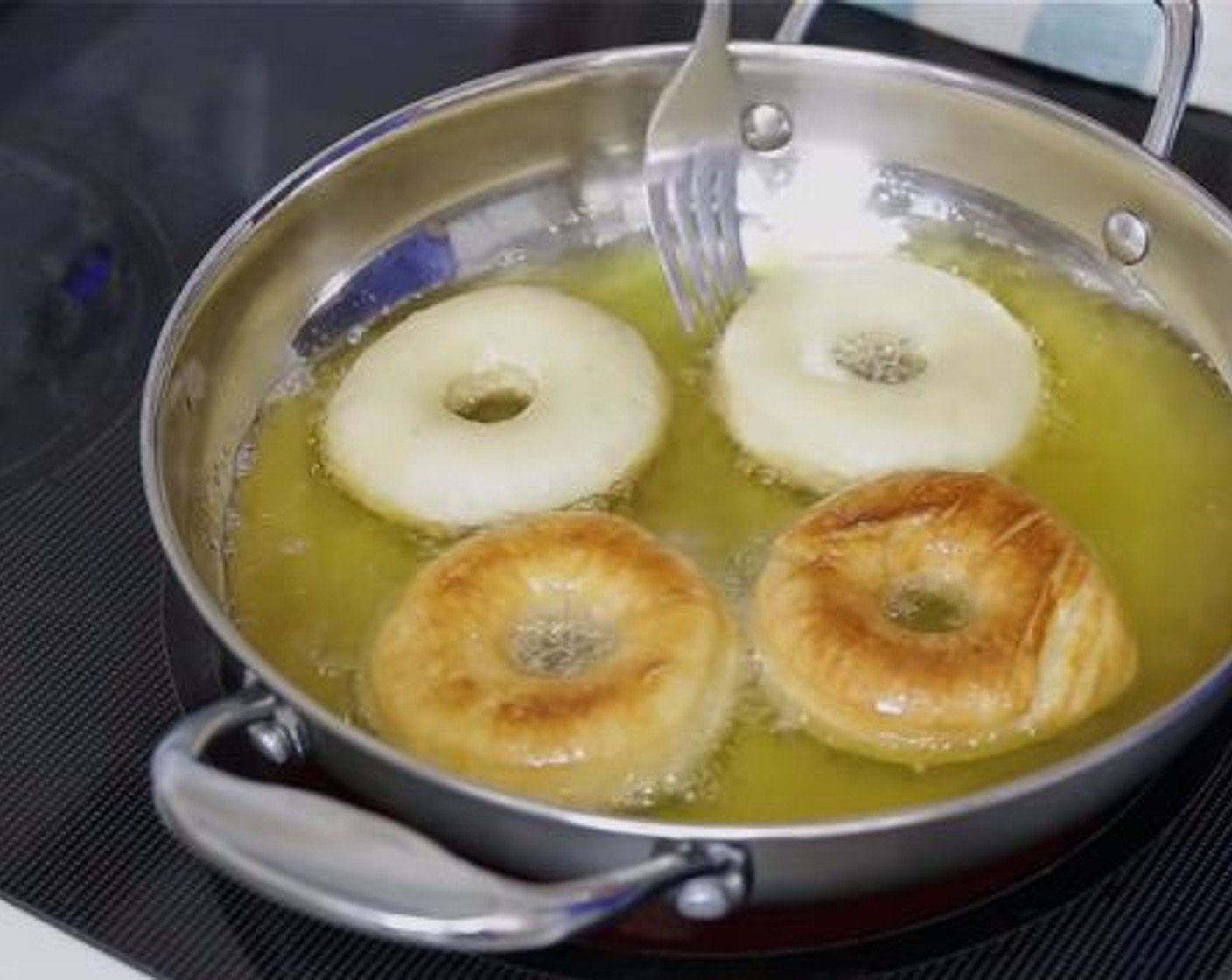 step 7 Once donuts doubled again, start frying them on hot oil over medium heat until golden brown on both sides. Remove from oil and place them on a cooling rack. Dip each donuts in the glaze allowing the excess glaze to drip off.