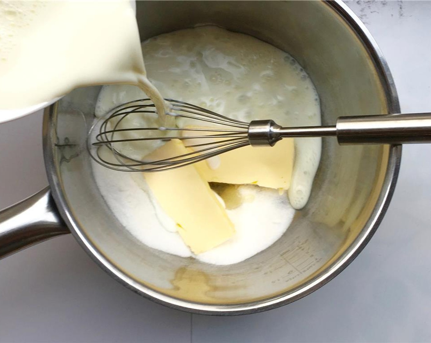 step 1 Pour the Milk (2 cups) and Caster Sugar (1/4 cup) in a large saucepan and add the Unsalted Butter (4 Tbsp) and Vanilla Essence (2 drops).