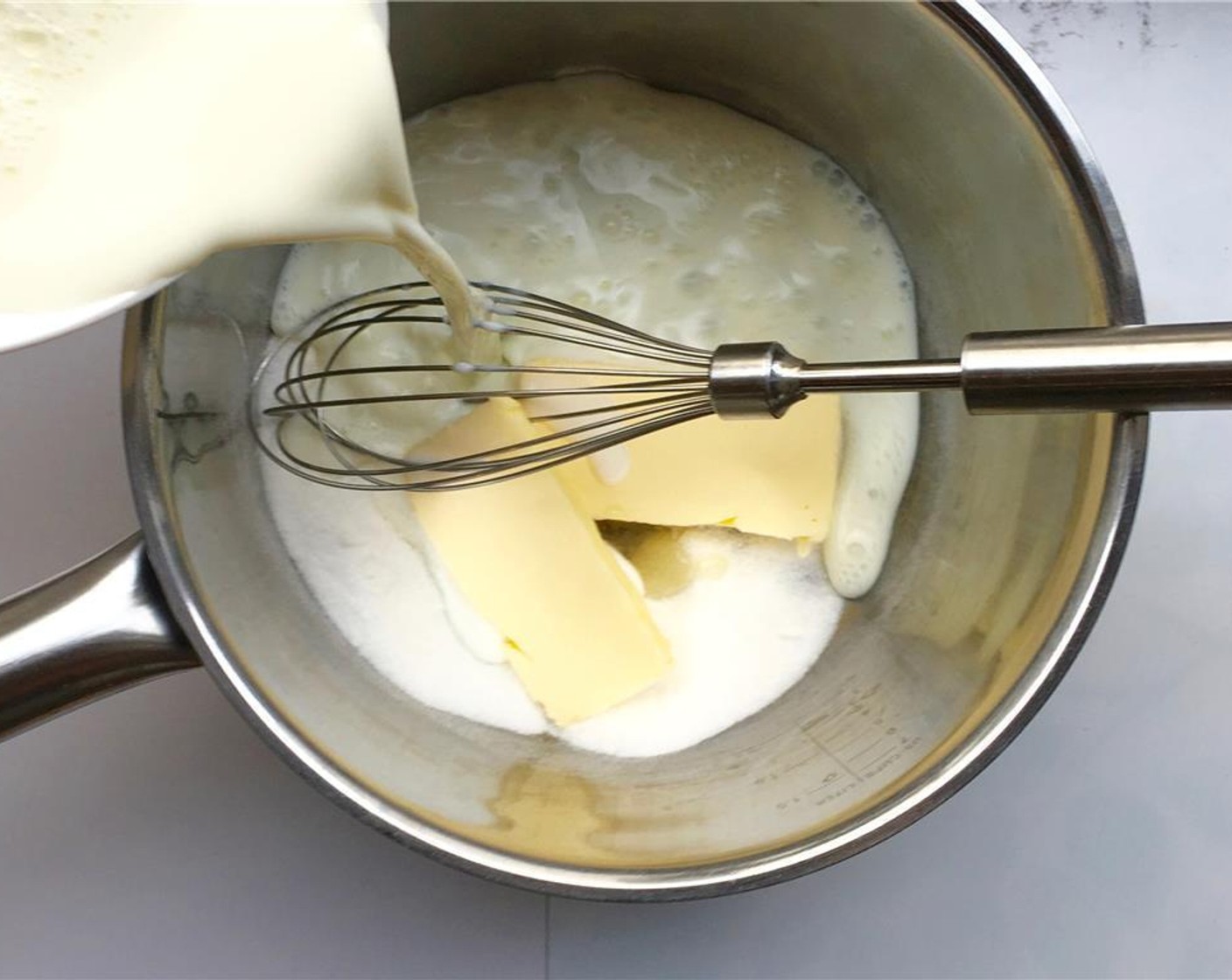 step 1 Pour the Milk (2 cups) and Caster Sugar (4 Tbsp) in a large saucepan and add the Unsalted Butter (4 Tbsp) and Vanilla Essence (2 drops).