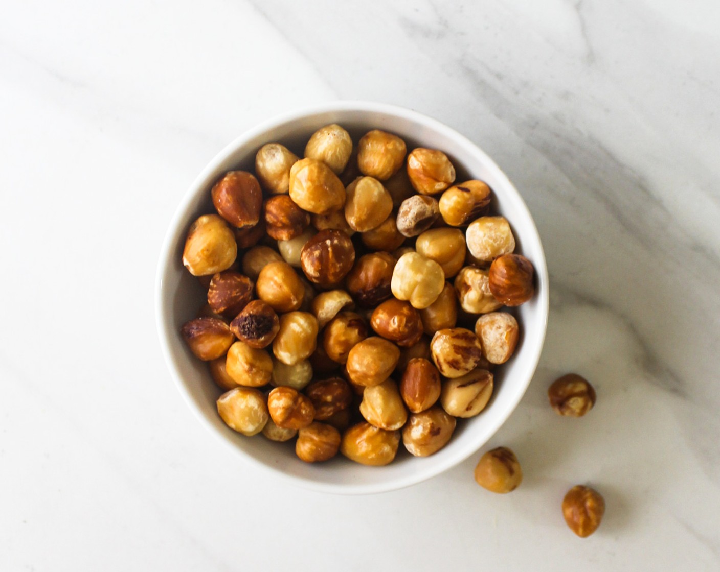 step 1 Preheat the oven to 350 degrees F (180 degrees C). If you are using unpeeled hazelnut, remove their skin by rubbing them using a kitchen towel.