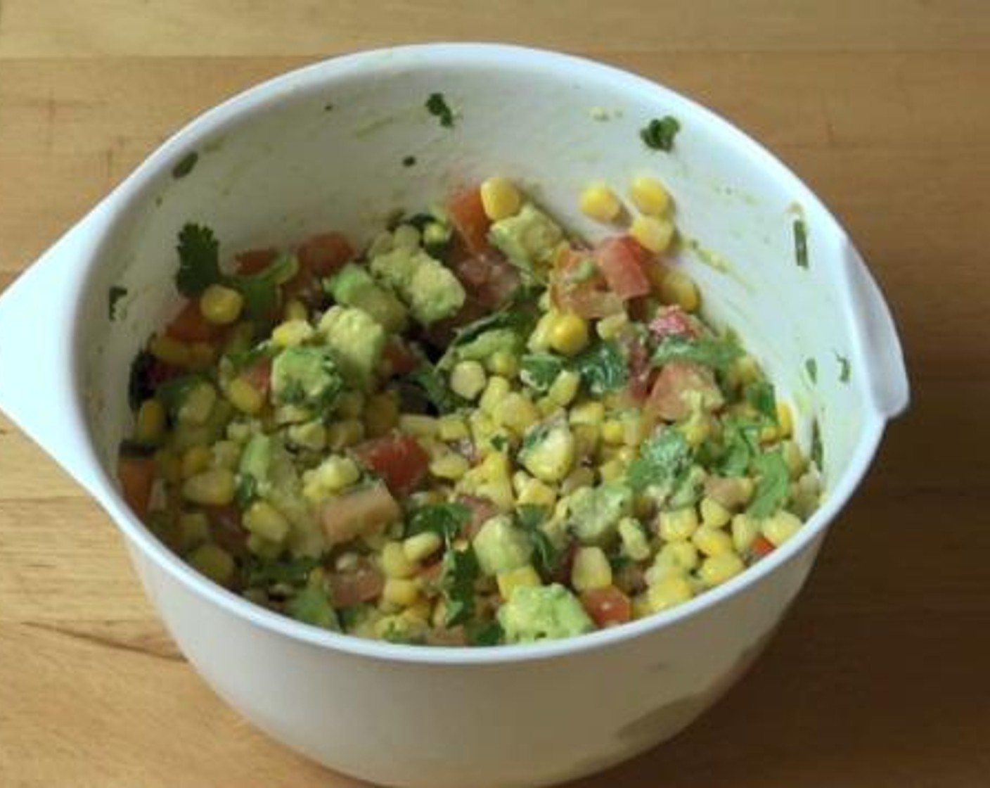 step 1 Into a mixing bowl, add and mix the Corn Kernels (2 1/4 cups), Avocado (1), Fresh Cilantro (1/2 cup), Tomatoes (2), juice from a Lime (1), Salt (to taste) and Ground Black Pepper (to taste). Set aside.