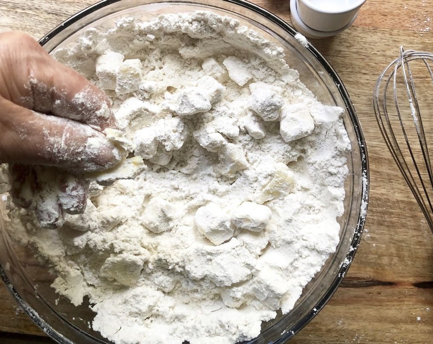 step 2 Add the Unsalted Butter (1 cup) to the flour mixture. Toss to coat it in the dry ingredients. Flatten each chunk of butter between your thumb and forefinger so that it's about an 1/8-inch thick.