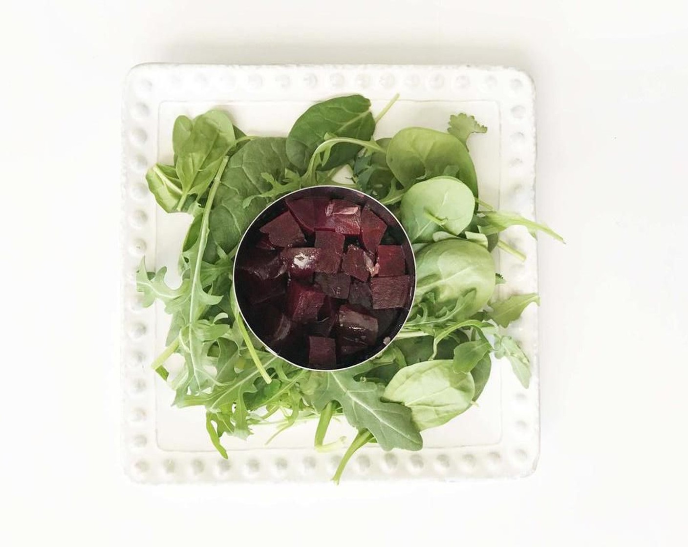 step 2 Once the beets have soaked in the vinegar goodness, prepare each of your plates with 1 1/4 cup of the Spinach and Arugula Mix (5 cups) and use a ring mold to divide the beets evenly among the plates as the bottom layer of the stack.