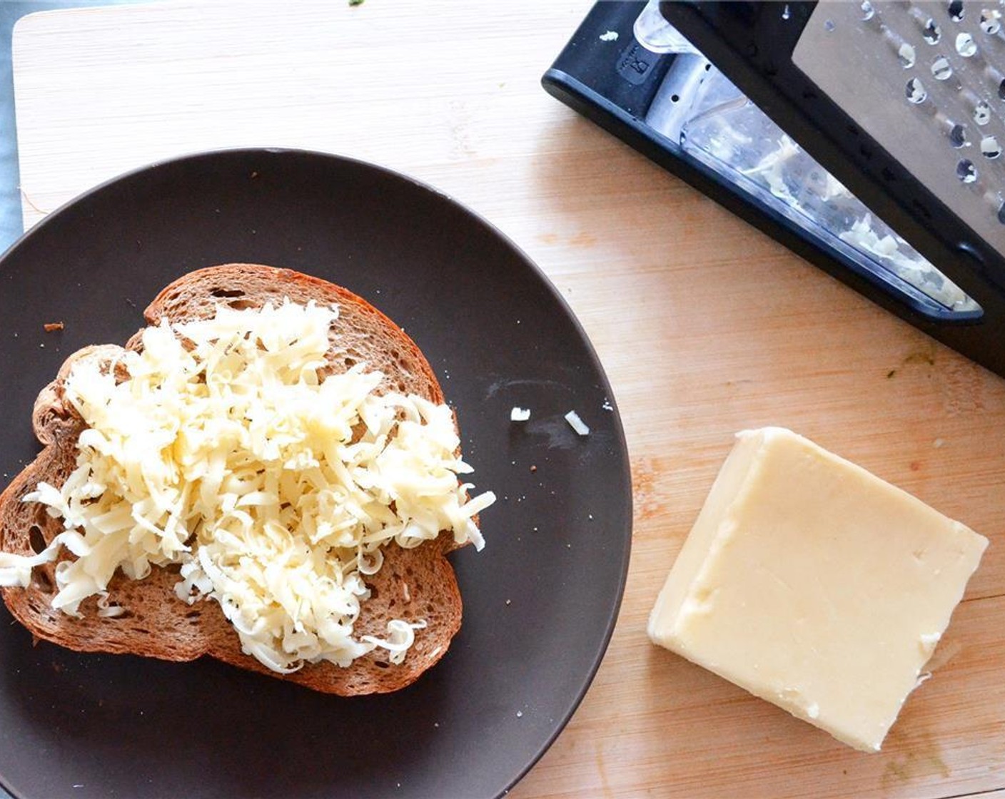 step 5 Sprinkle half of the cheese onto the unbuttered side of one slice of bread.