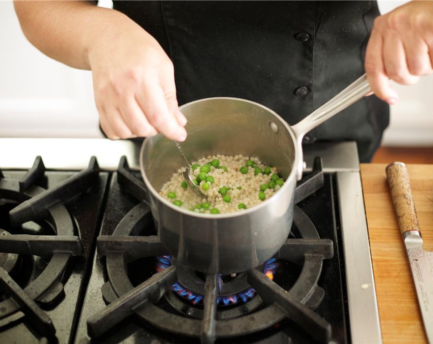 step 12 In the same saucepan used for couscous, melt the Butter (1/4 cup) over medium heat. Add the remaining minced garlic with Green Peas (1/2 cup) and cook for one minute.