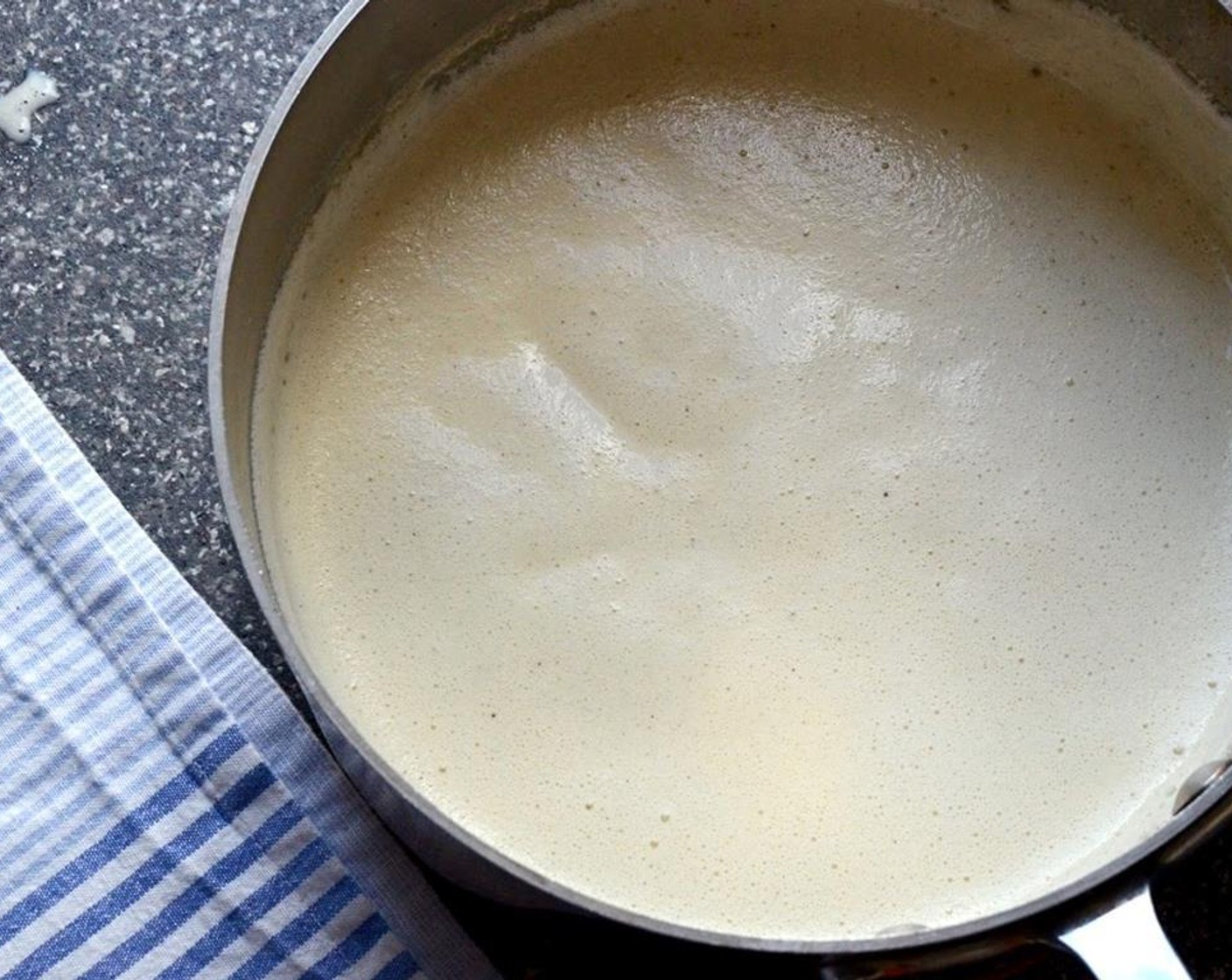 step 4 In a slow, steady stream, beat the hot half and half into the eggs.  Pour the egg mixture back into the pan and place over low heat, stirring constantly with a wooden spoon or whisk until mixture thickens. Remove from heat.