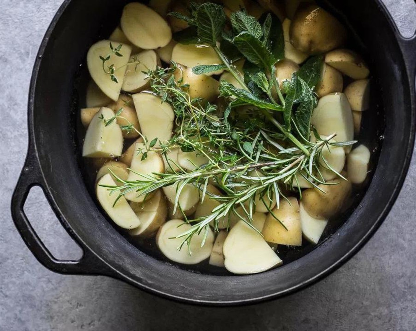 step 1 Cut New Potatoes (3 cups) in half (larger potatoes can be chopped into four small pieces) and add them to a pot. Cover with water, add Salt (1 Tbsp), Fresh Rosemary (2 sprigs), Fresh Mint (2 sprigs) and Fresh Thyme Leaves (2 sprigs) and bring to a boil. Once boiling, cook potatoes for about ten minutes, checking the potatoes at about eight minutes for doneness.