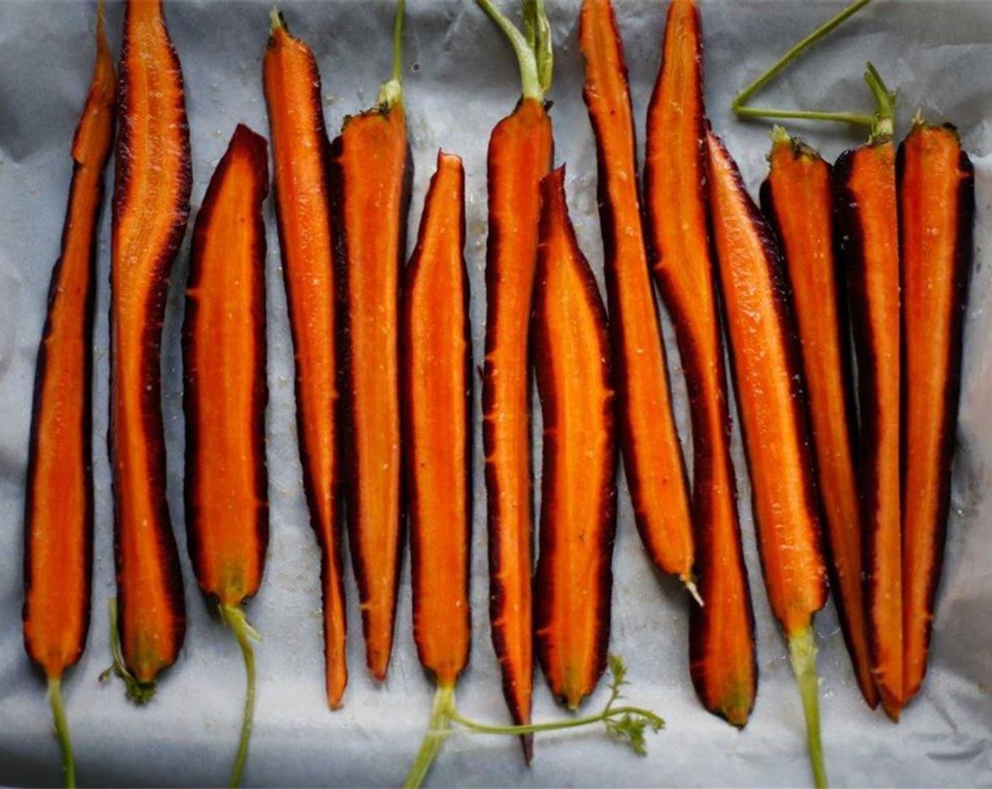 step 3 Lay the carrots flat onto a parchment-lined roasting sheet. Roast at 375 degrees F (190 degrees C) for 1 hour. The carrots should have softened yet still have some bite to them. Cooking time will depend on the size of the carrots and the strength of the oven.