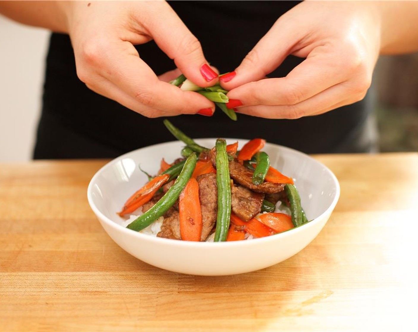 step 10 Divide the rice evenly between two plates. Top with the mongolian beef and a little extra sauce if desired. Garnish with the remaining green onions. Have a delicious dinner!