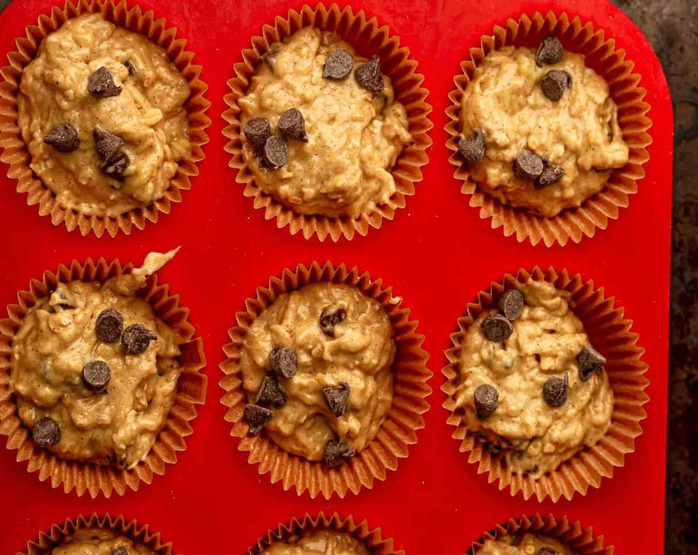 step 4 Evenly distribute the batter throughout the muffin tin, filling each cup almost to the top, about 3/4 way full. Sprinkle additional oats and chocolate chips on the top of each muffin, if desired.