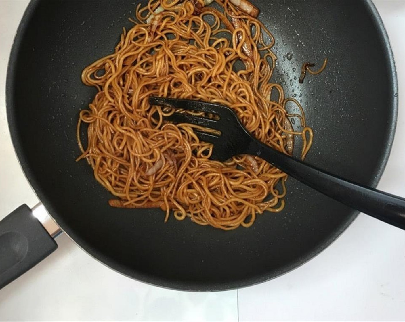 step 5 Stir fry and toss the noodles well until the soy sauce is evenly divided and has colored the noodles.