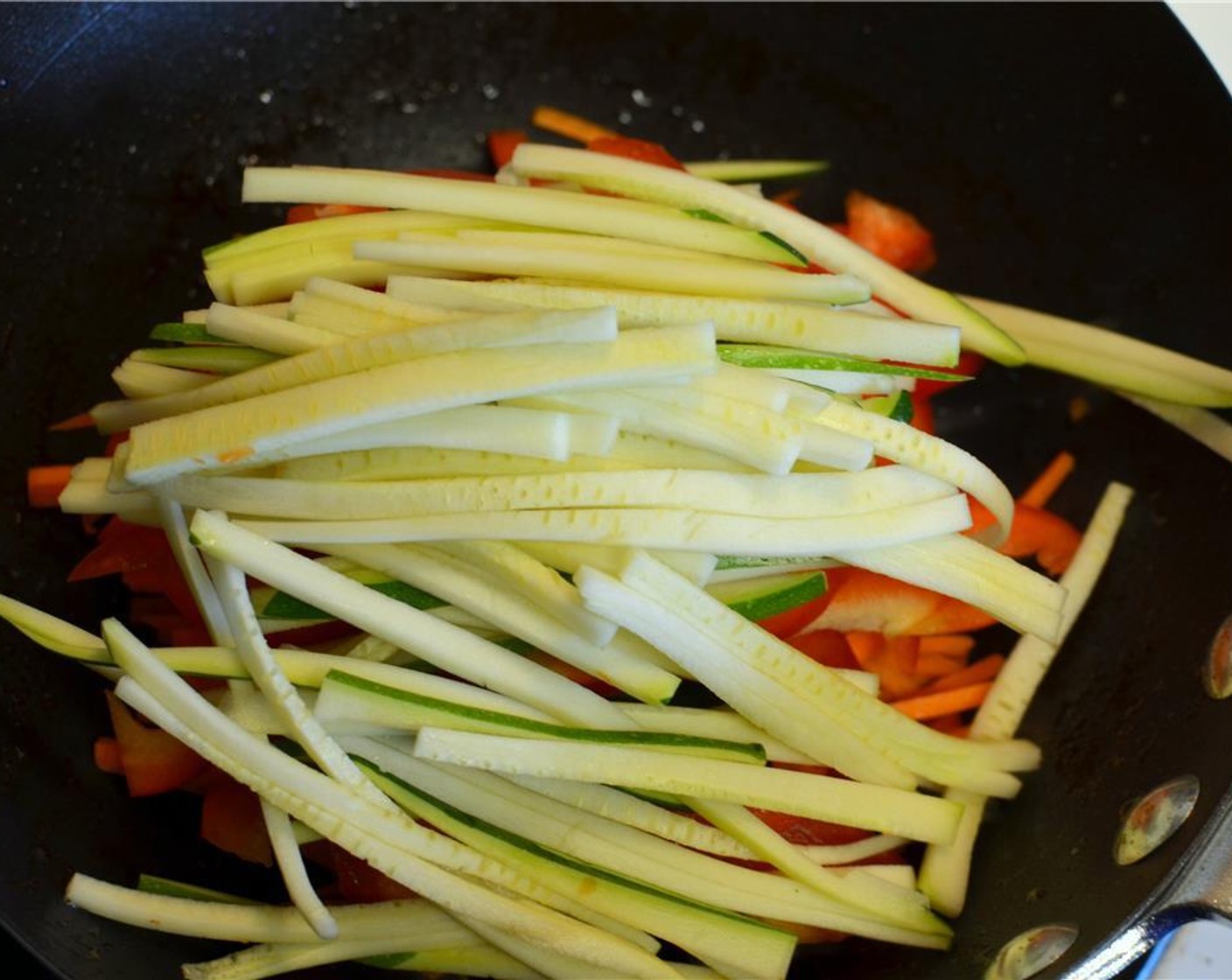 step 10 Turn the heat up to high and toss in the carrot, bell pepper and zucchini and stir fry the veggies for no longer than 2-3 minutes.