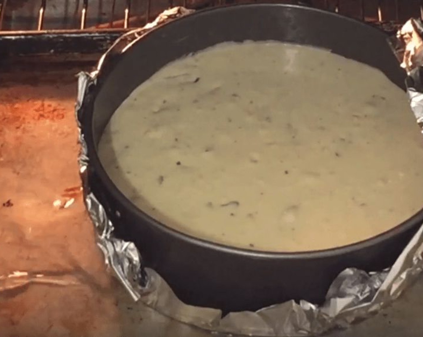 step 11 Place the cheesecake on top of a baking sheet. Pour hot water onto the baking sheet. Pour enough water to come up to the sides.