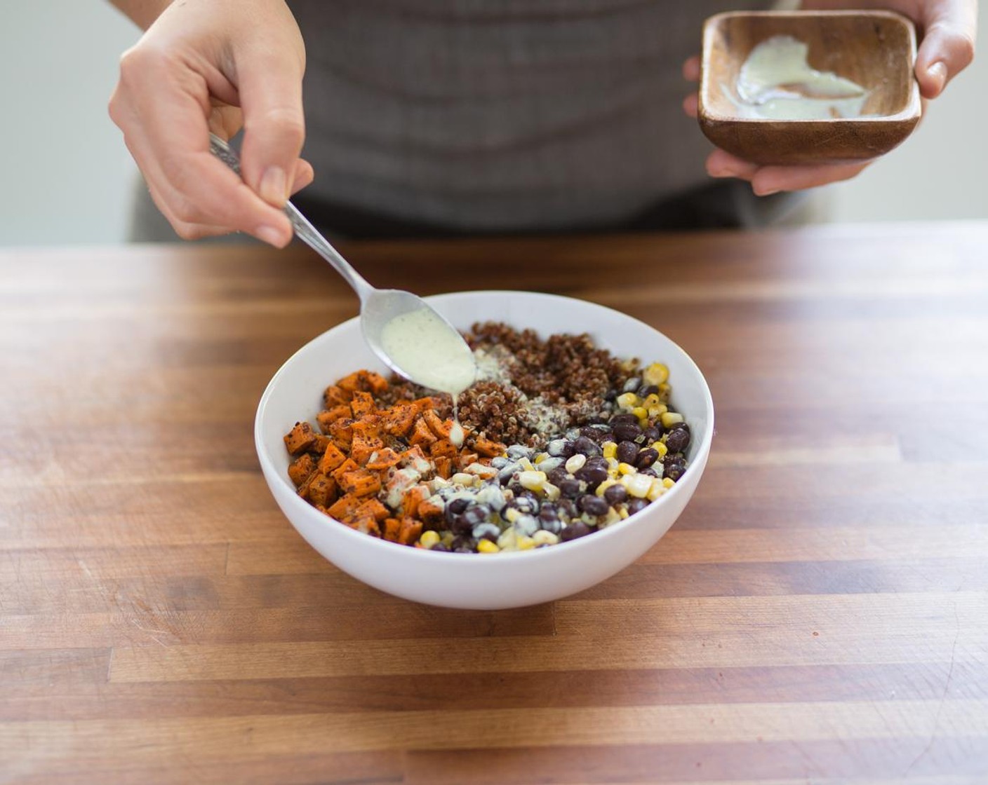 step 10 In the center of two bowls, place the quinoa. Top each serving with corn, roasted sweet potatoes and black beans. Drizzle with the cilantro crema. Serve and enjoy!