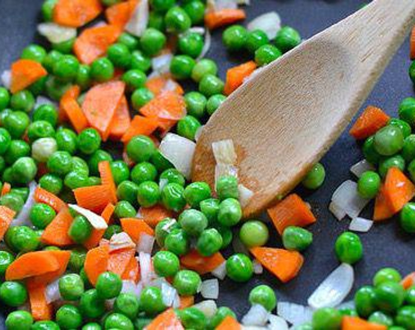step 1 Saute Onion (1) in Sesame Oil (1 Tbsp) in a pan or wok on medium high heat until translucent, then add Garlic (3 cloves) and saute for ten seconds and add Frozen Peas and Carrots (2 cups). Stir fry until vegetables start getting tender.