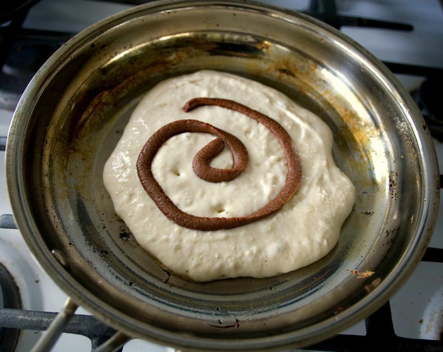 step 5 Over medium-high, heat a large frying pan and coat with nonstick cooking spray. Add 1/4 cup of pancake batter to the pan. Cook until the pancake's edges start to form bubbles, about 2 minutes, then "pipe" a swirl of the cinnamon filling.