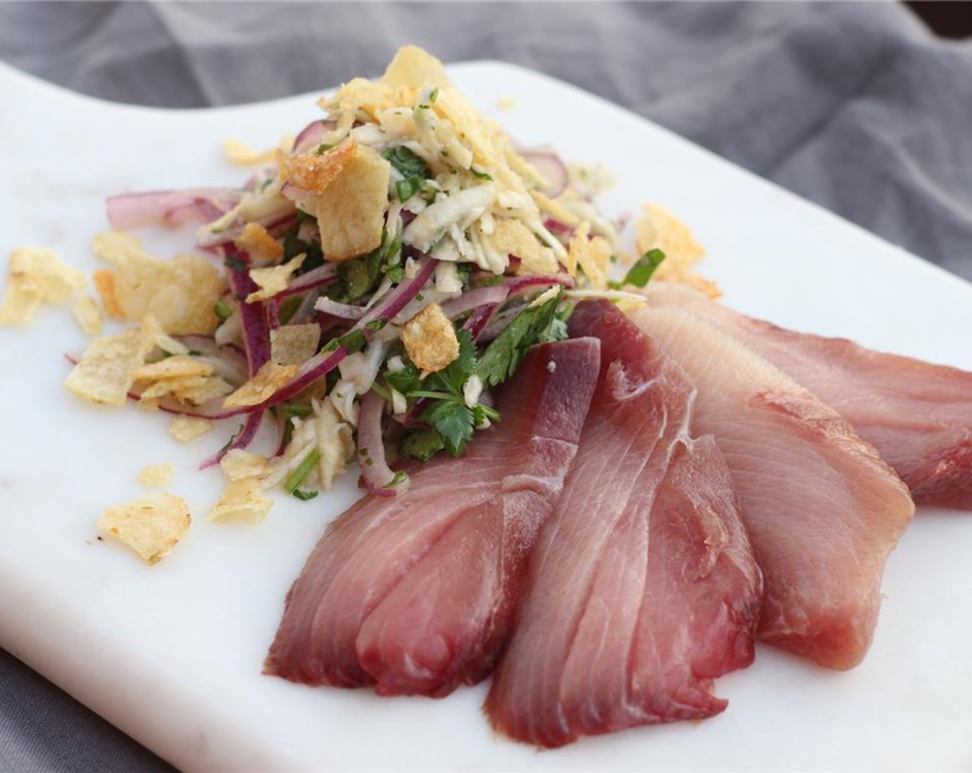 step 13 Thinly slice each Hamachi fillet on a bias cut into half-inch slices. Serve cold on plates with kohlrabi slaw topped with potato chips on the side. Enjoy!