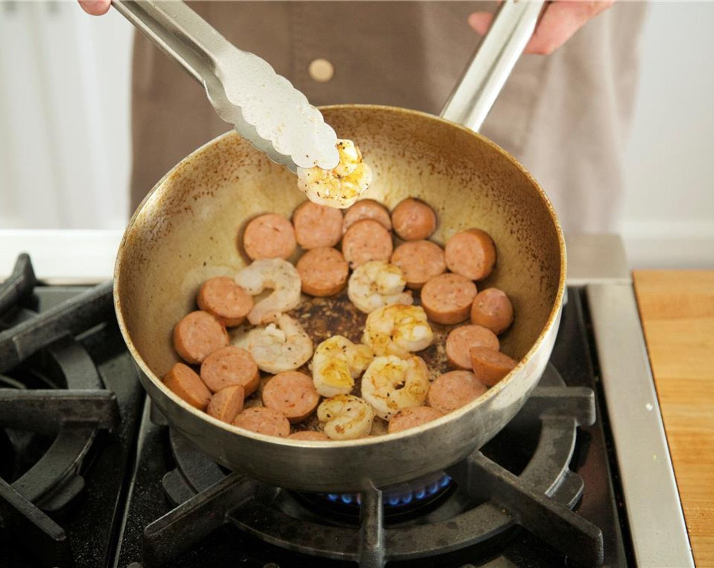 step 12 Add sausage and shrimp to pan. Sear sausage on one side for two minutes, flip shrimp after one minute and cook another minute on the opposite side. Remove sausage and shrimp, and add to the chicken in the bowl.