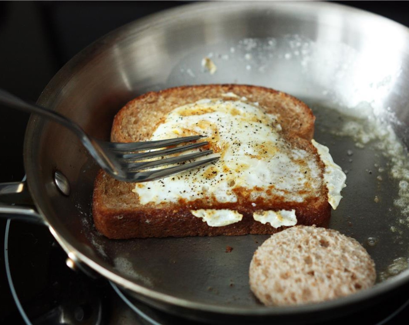 step 5 Then carefully slide a spatula under the bread and flip. Sprinkle a bit more pepper on the second side, then flip the cut-out circle to grill the other side.