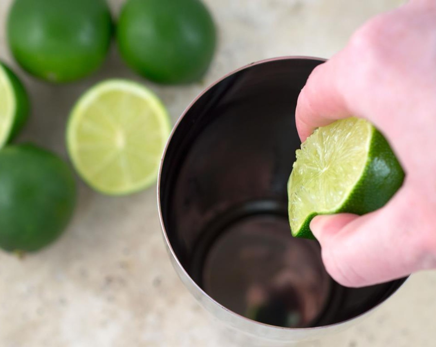 step 4 Add PATRÓN® Silver Tequila (2 fl oz) and juice from Limes (3) into a cocktail shaker or into a measuring cup. Add the simple syrup (water and sugar mixture).