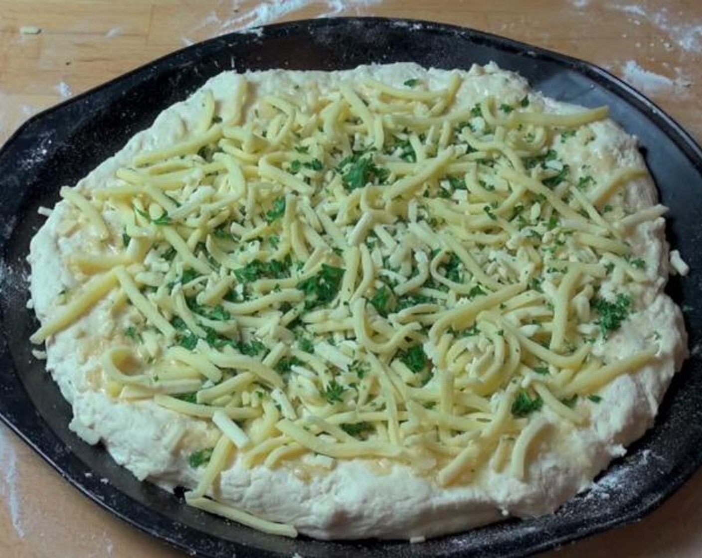 step 3 In a small cup, combine Olive Oil (1/4 cup) and Garlic (2 cloves). Spread mixture over the dough. Sprinkle Fresh Parsley (2 Tbsp) and Cheese (1 cup) over top.