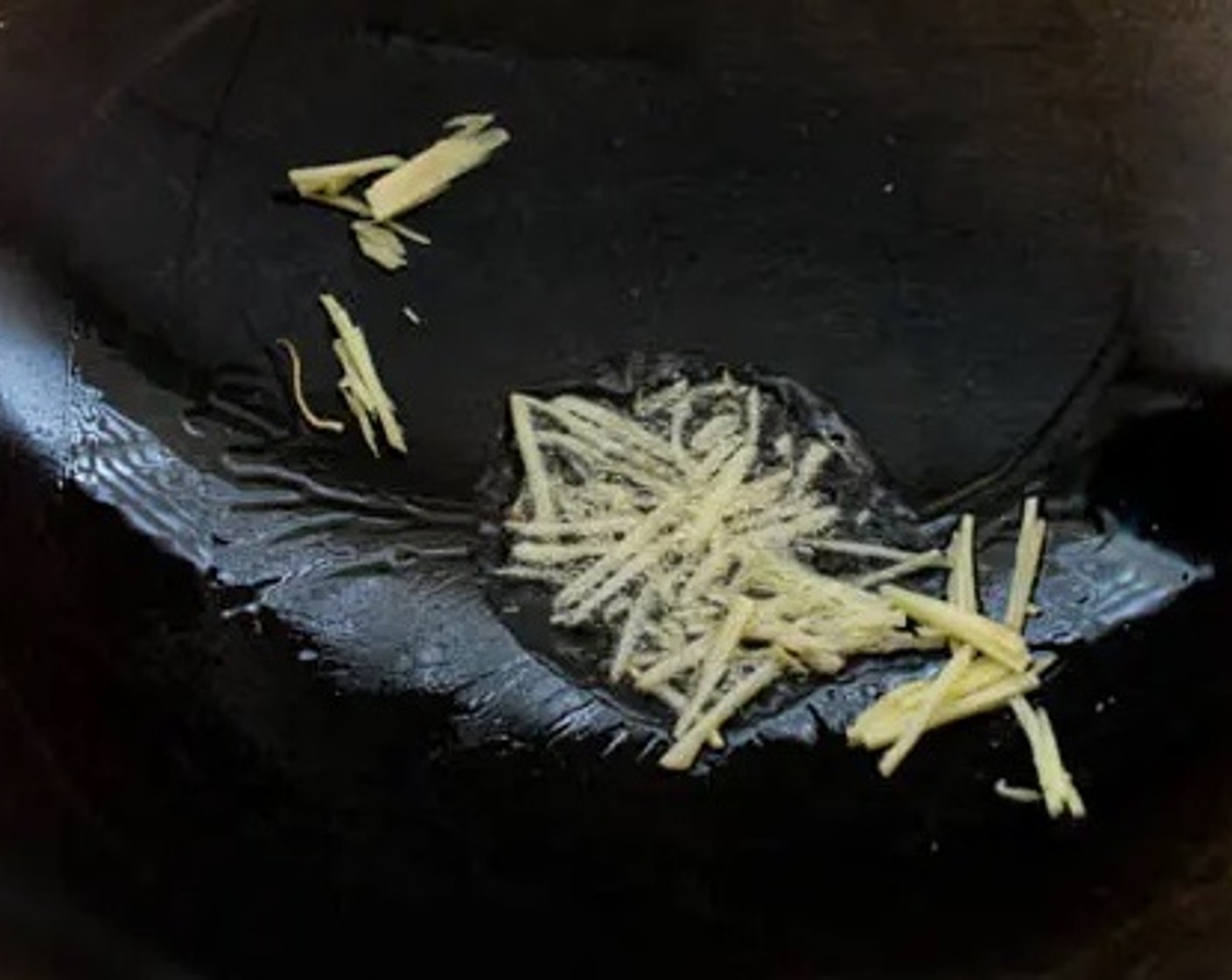 step 4 Heat Oil (2 Tbsp) in a wok over high heat. As the oil is heating up, add Fresh Ginger (2 Tbsp) to the wok.