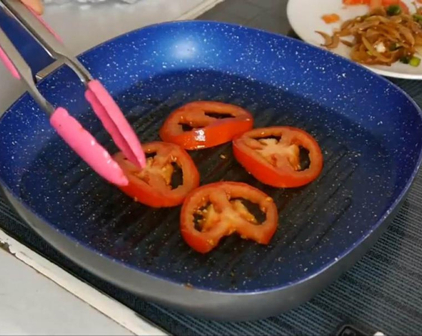 step 6 Once the onions are cooked remove from the pan and add the tomato slices cooking them for a minute and half on each side so they are slightly soft.