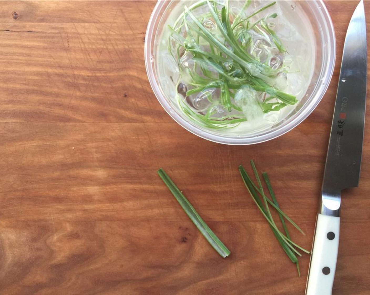 step 16 For the garnish, slice 2-inch segments off the green ends of the Scallions. Vertically slice into long, thin slices. Place in a small bowl of ice water, so they curl up. Set aside.