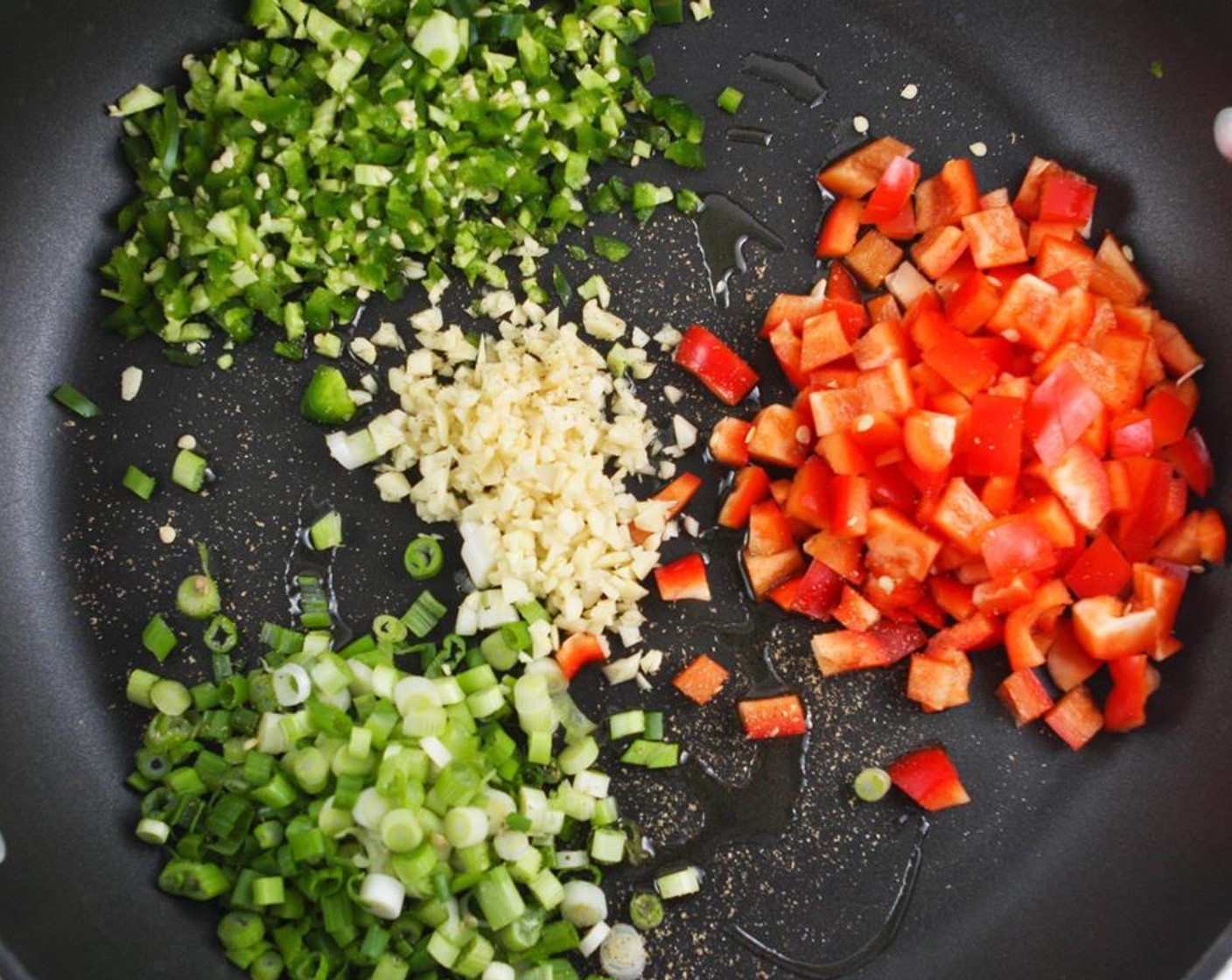 step 1 Heat Extra-Virgin Olive Oil (3 Tbsp) in an extra-large skillet over medium heat. Add Garlic (4 cloves), Red Bell Pepper (1), Scallion (1 bunch), Jalapeño Peppers (2), Salt (to taste), and Ground Black Pepper (to taste). Cook 3-4 minutes.